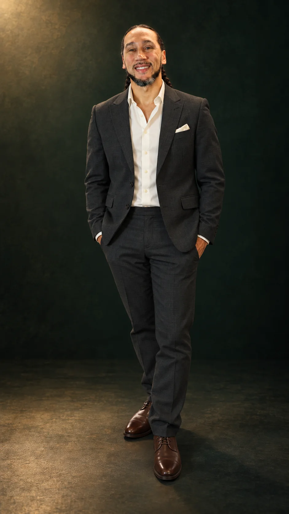 Will Foxx, founder of Legacy Sterling, standing in a charcoal suit against a dark green studio backdrop